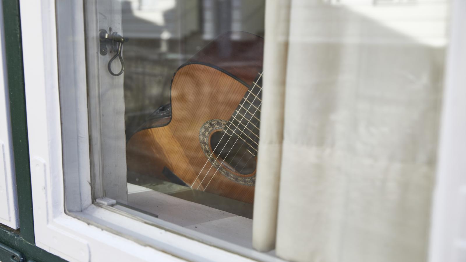 Eine Gitarre hinter einem Fenster des AStA-Büros in der Großen Petersgrube 21 