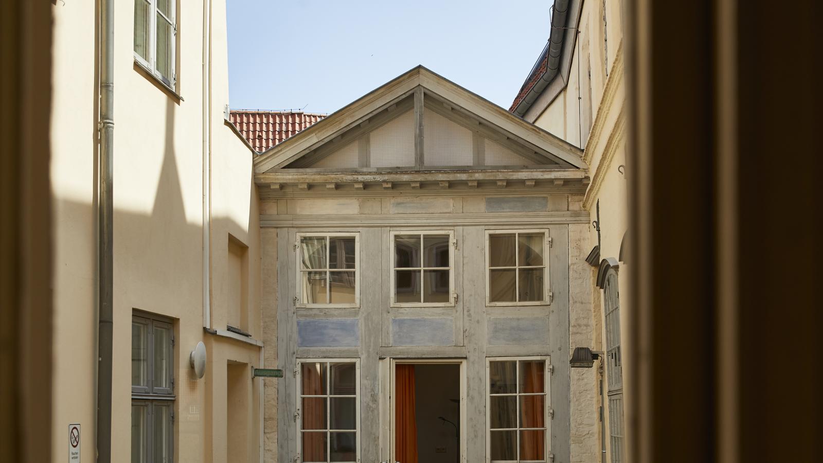Blick auf den kleinen Küchenhof in Richtung der kleinen Giebelfassade aus Fachwerk.