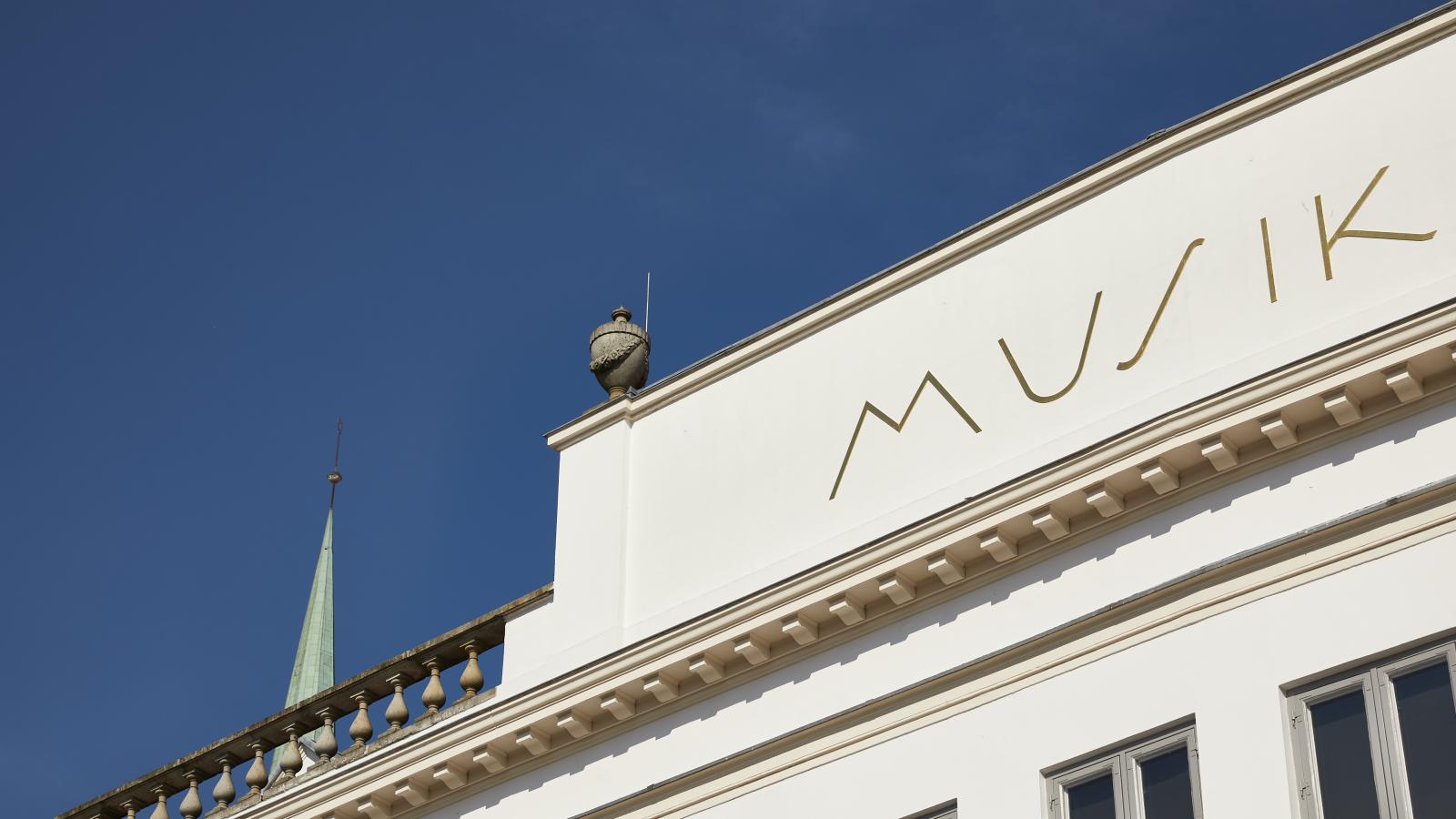 Blick auf die Attika des klassizistischen Gebäudes an der Obertrave, in dem der Kammermusiksaal der MHL liegt