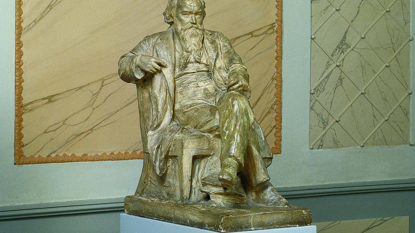 Blick auf eine Büste von Johannes Brahms, leger sitzend auf einem Stuhl