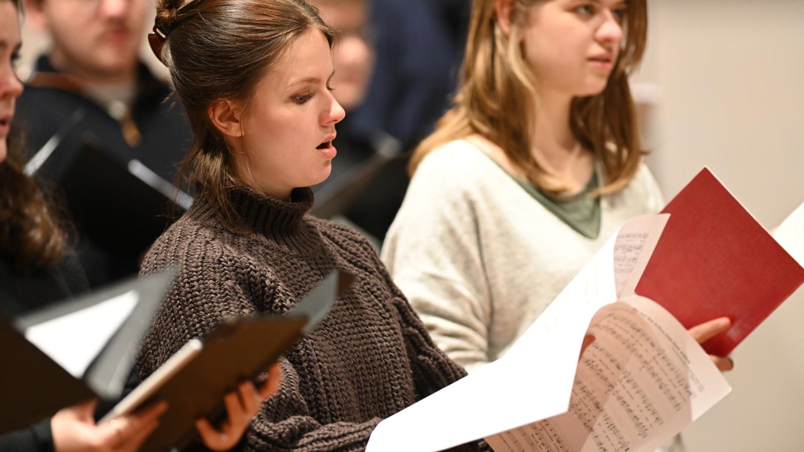 Blick auf eine singende Gesangsstudentin bei einer Ensembleprobe