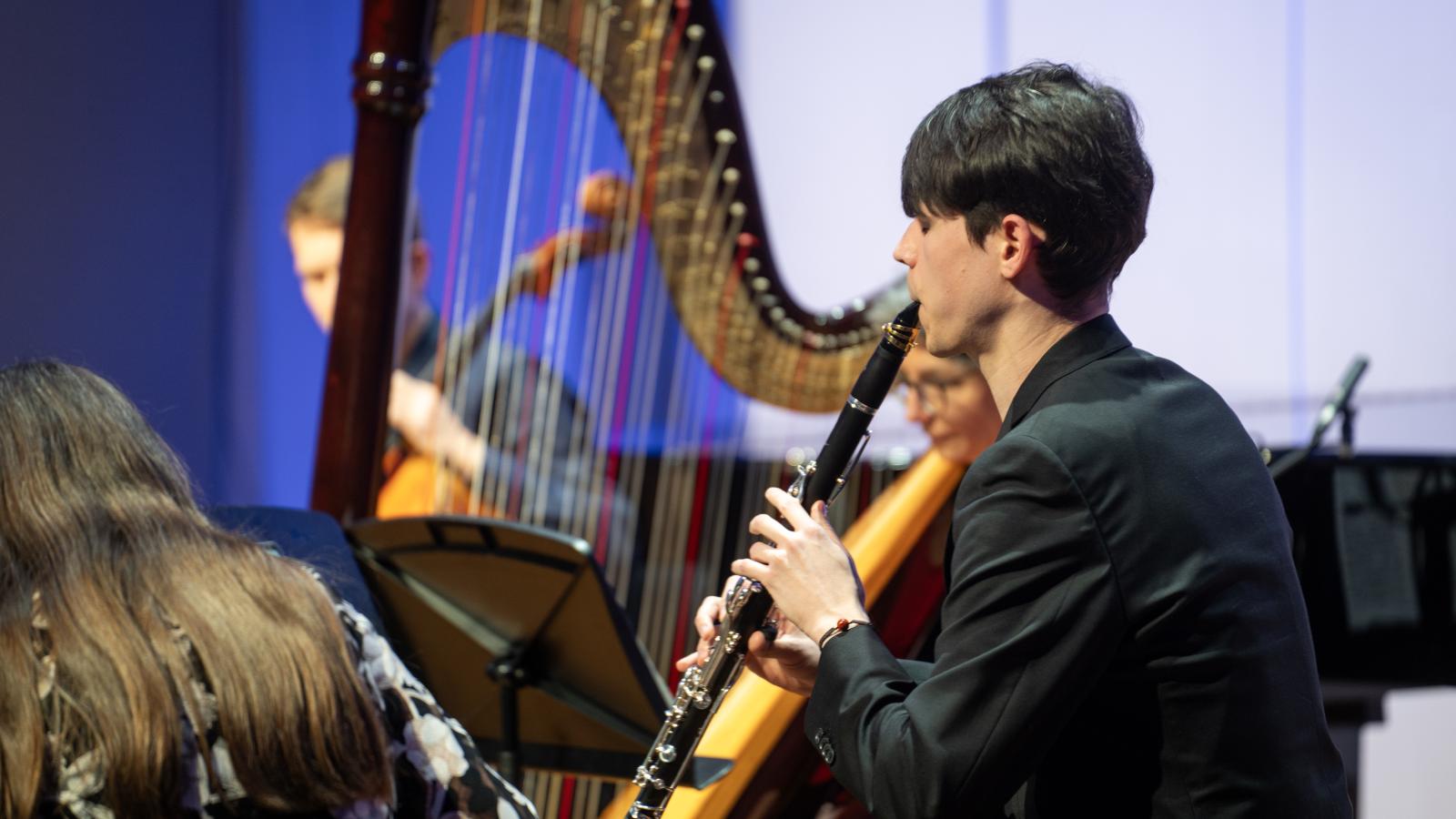 Blick auf einen Klarinettisten, der auf der Bühne des Großen Saals musiziert.