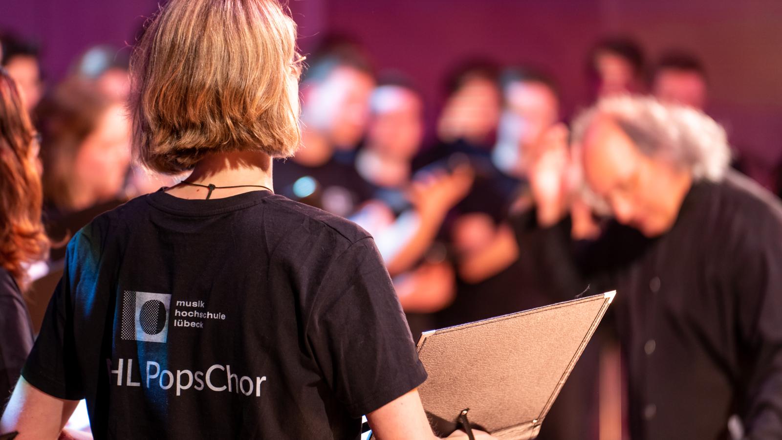 Blick auf Studierende der MHL, die auf der Bühne des Großen Saals der MHL singen und spielen