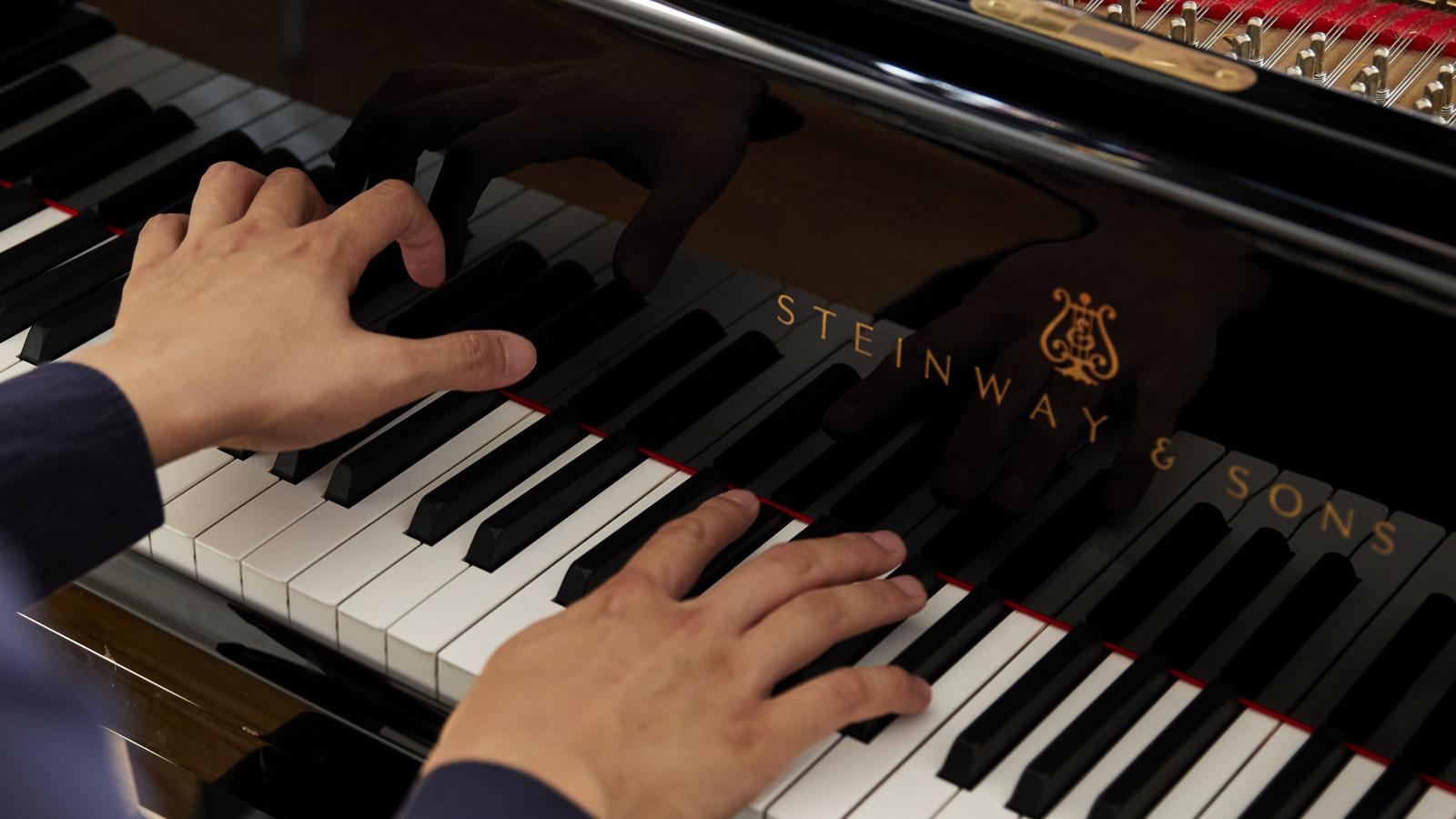 Blick auf einen klavierspielenden Studenten