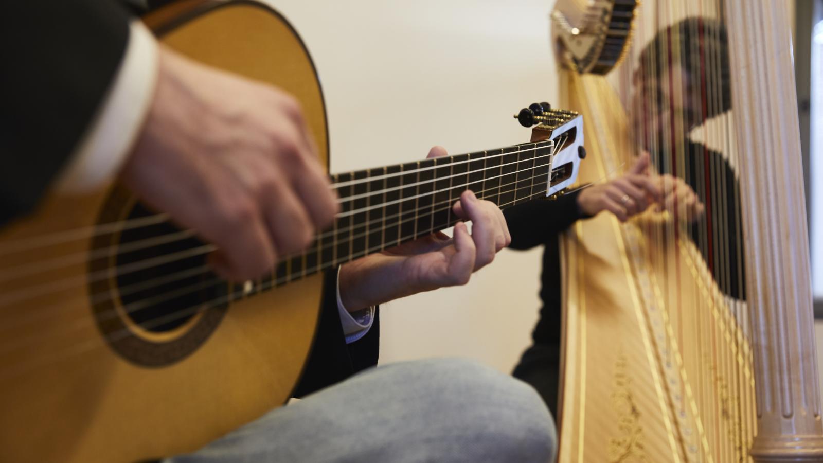 Blick auf zwei Dozierende der MHL, die Gitarre und Harfe zusammen spielen.