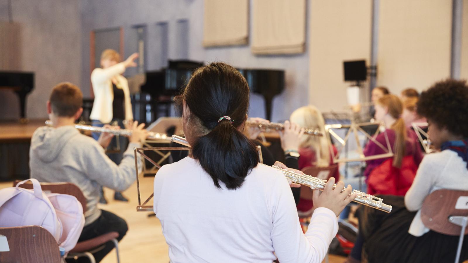Blick auf musizierende Kinder und Jungendliche, die im Flötenspiel unterrichtet werden