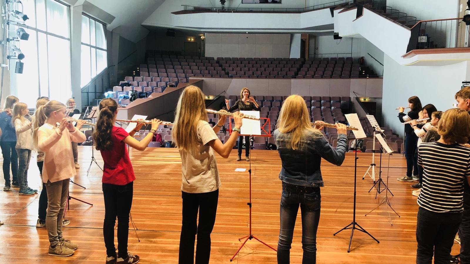 Blick auf eine Gruppe von musizierenden Querflötenspieler von der Bühne des Großen Saals der MHL in den Zuschauerraum