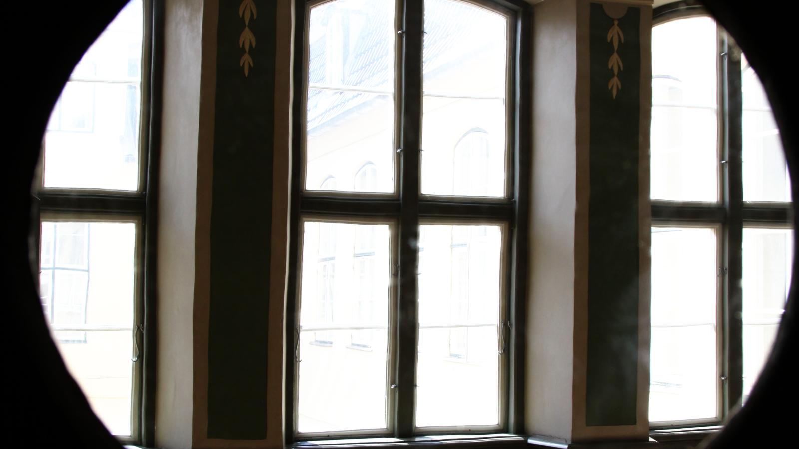 Blick von einem runden Türfesnter in die Galerie von Haus Nr. 21