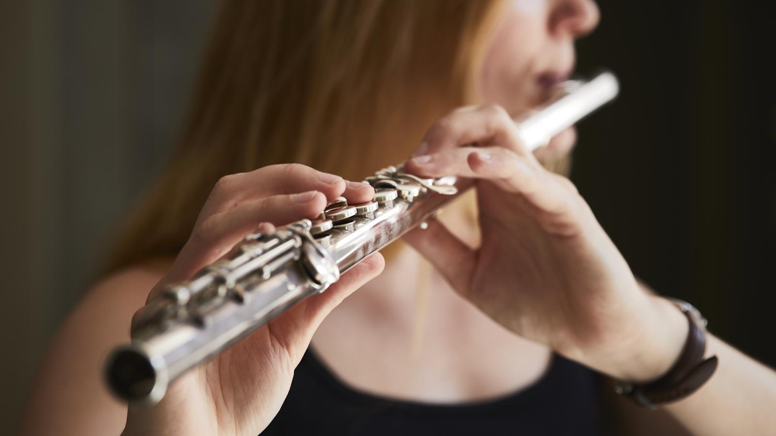 Blick auf eine Flöte spielende Studentin