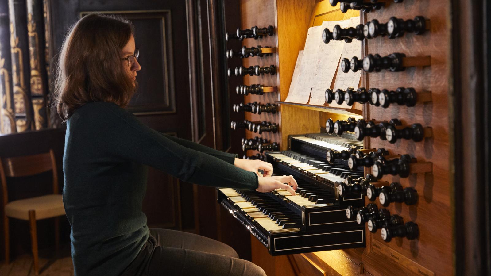 Blick auf eine Orgel spielende Studentin