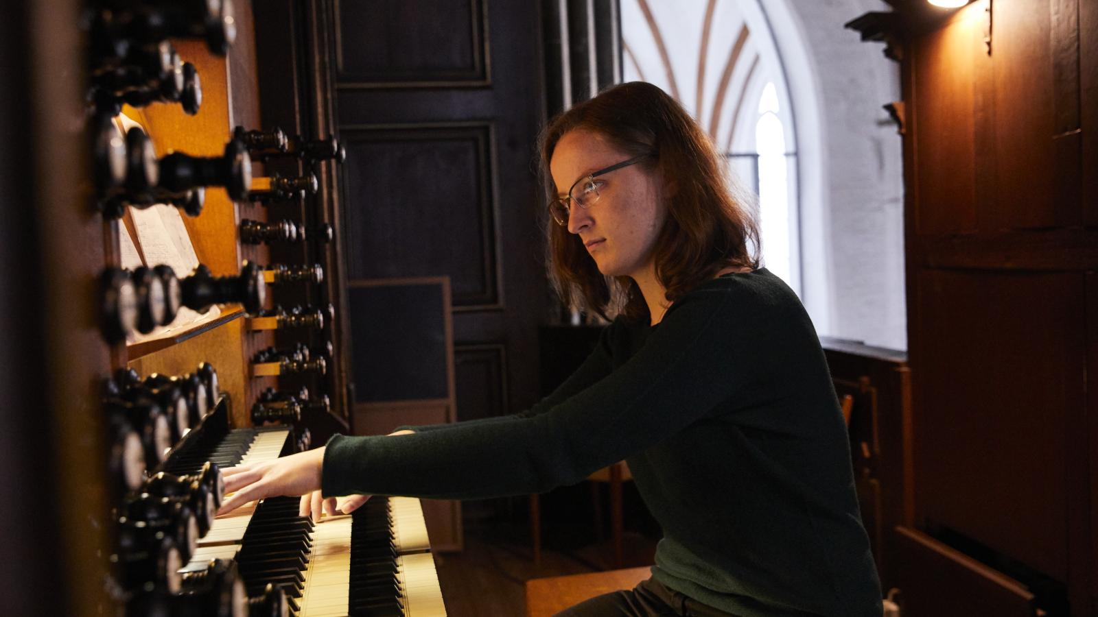 Blick auf eine Orgel spielende Studentin