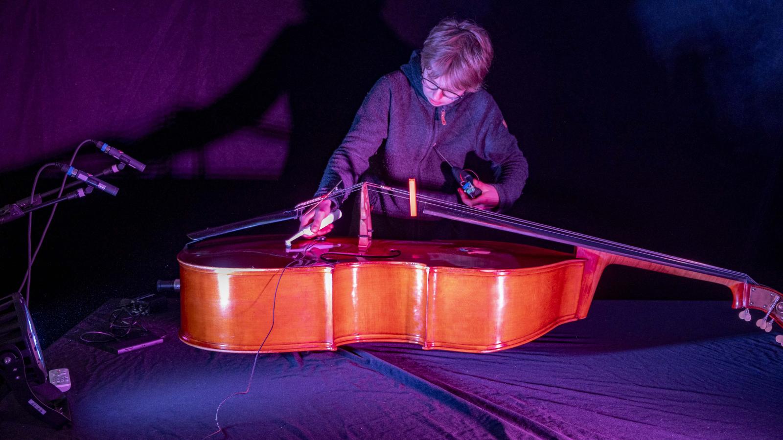 Blick auf einen Studenten, der einen Kontrabass technisch präpariert 