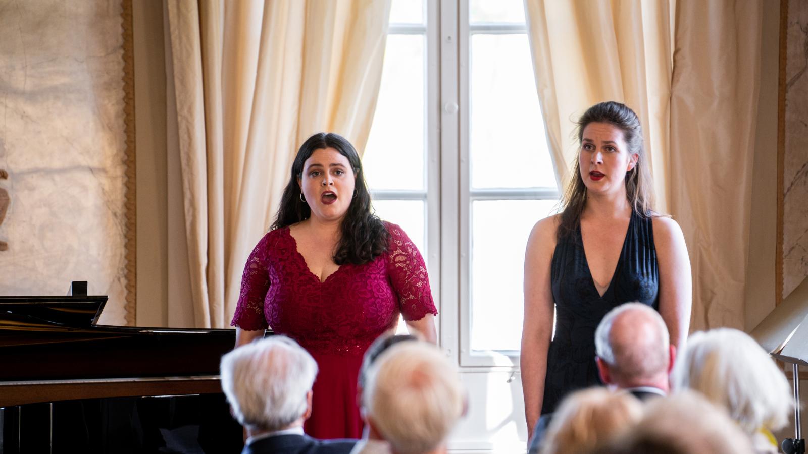 Blick auf zwei singende Studentinnen