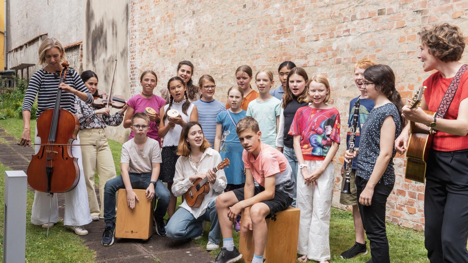 Blick auf eine Gruppe junger Schülerinnen und Schüler, die zusammen singen