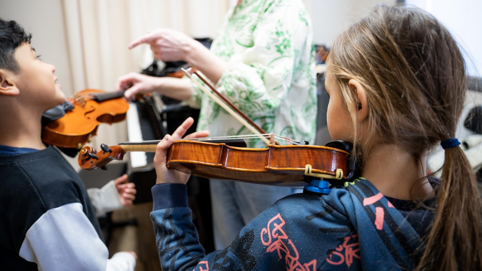 Blick auf zwei Kinder, die ein Instrument lernen