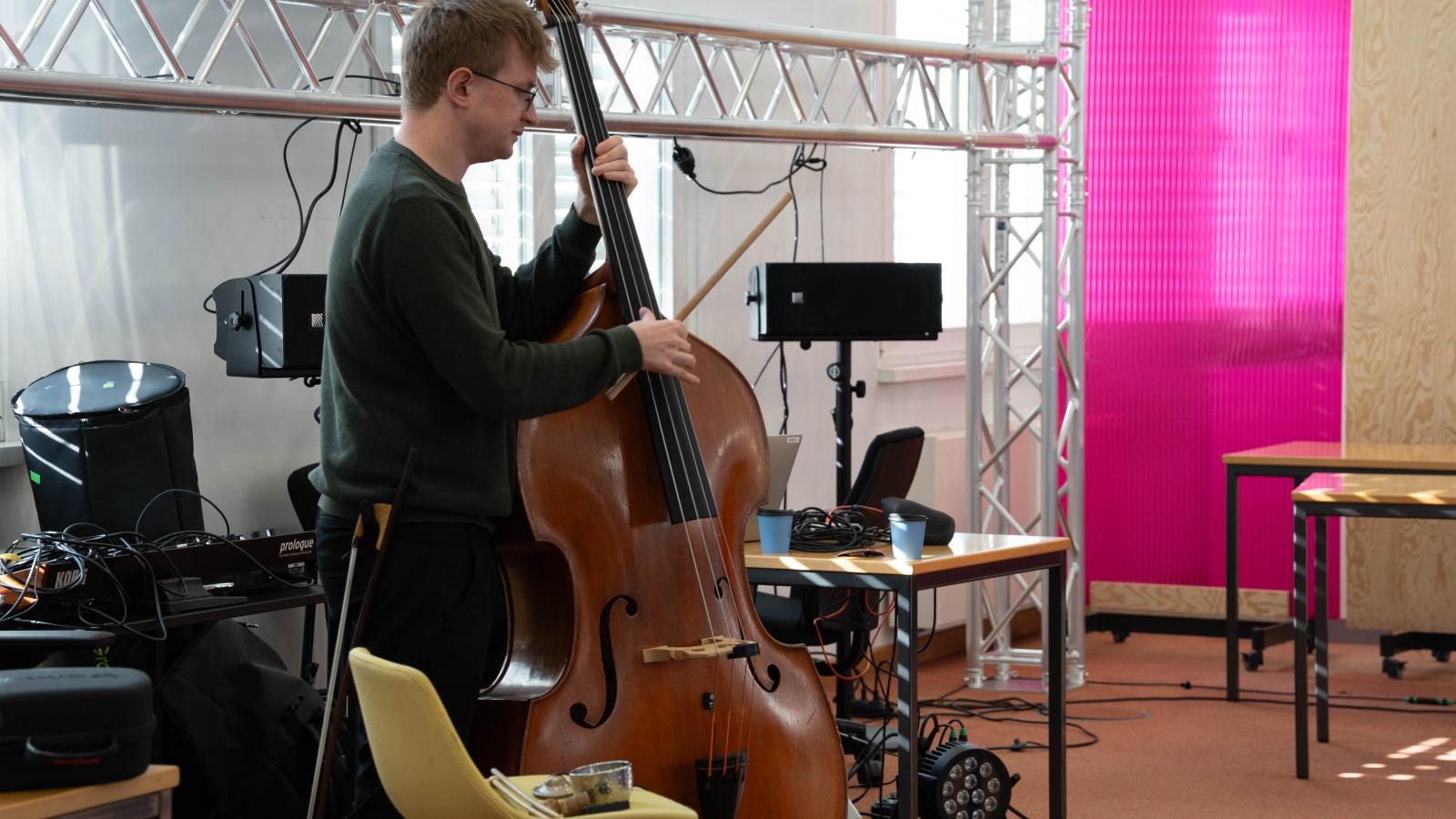 Blick auf einen Kontrabassisten, der mit Hilfe technischer Unterstützung im ehemaligen Bundesbankgebäude improvisiert