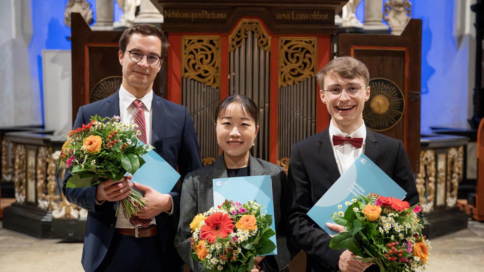 Die Preistragenden Gregor Früh Mio Kuriyama und Jannik Gerdes stehen nebeneinander