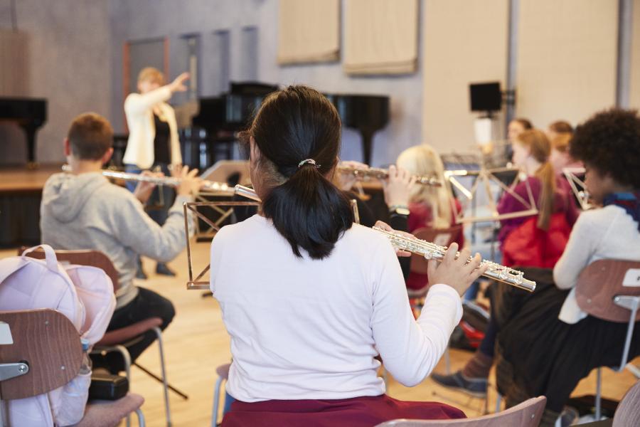 Blick auf eine Gruppe von jungen Schülerinnen und Schülern, die Flöte zusammen spielen