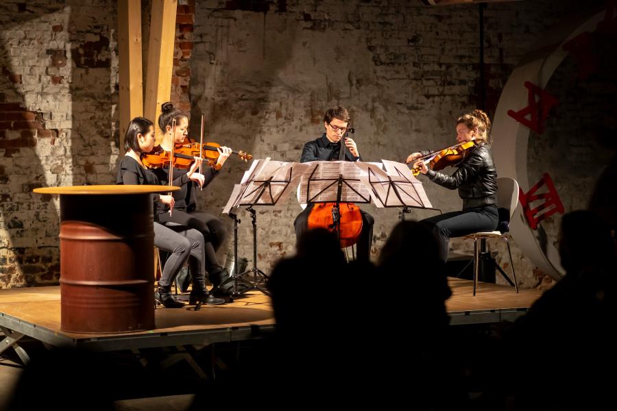 Ein Sreichquartett spielt an einem ungewöhnlichen Ort: in einem Lübeck Hafenschuppen 