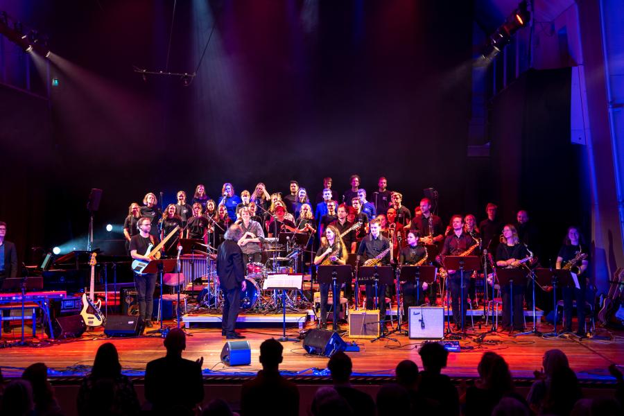 Blick auf die Bühne des Großen Saals der MHL mit einer Vielzahl an Studierenden, die eine Popwerkstatt aufführen