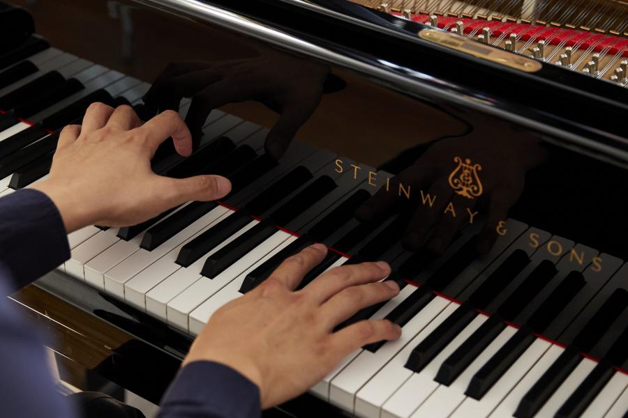 Blick auf einen klavierspielenden Studenten