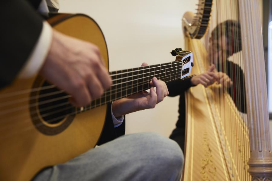 Blick auf zwei Dozierende der MHL, die Gitarre und Harfe zusammen spielen.