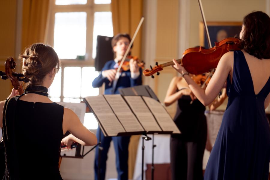 Blick auf Studierende, die in einem Konzert ein Streichquartett spielen