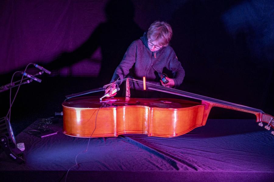 Blick auf einen Studenten, der einen Kontrabass technisch präpariert 