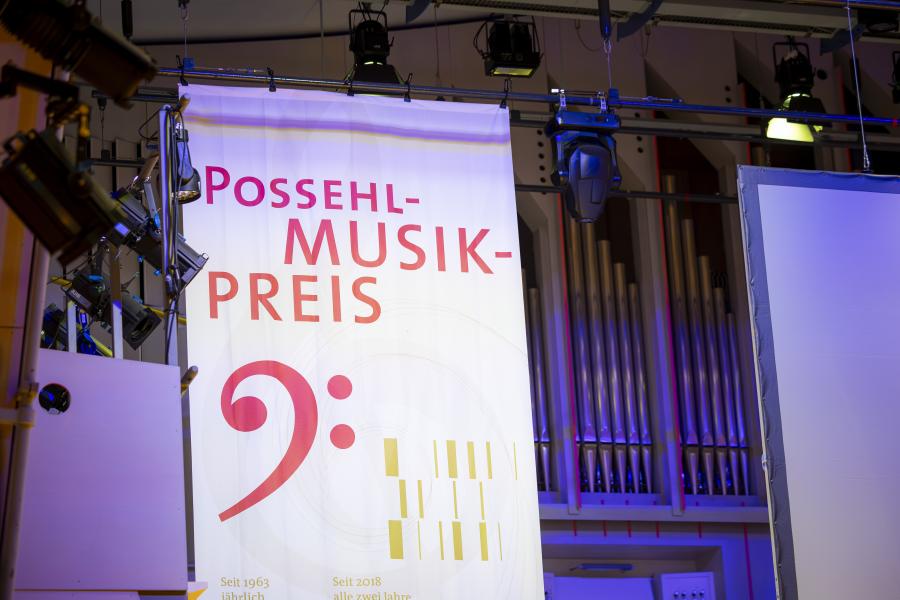 Blick auf das Banner des Possehl-Musikwettbewerbs, das über der Bühne im Großen Saal der MHL hängt