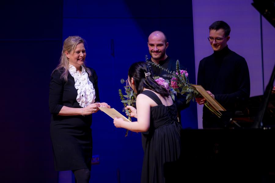 Eine Studentin bedankt sich für die Überreichung eines Stipendiums auf der Bühne des Großen Saals