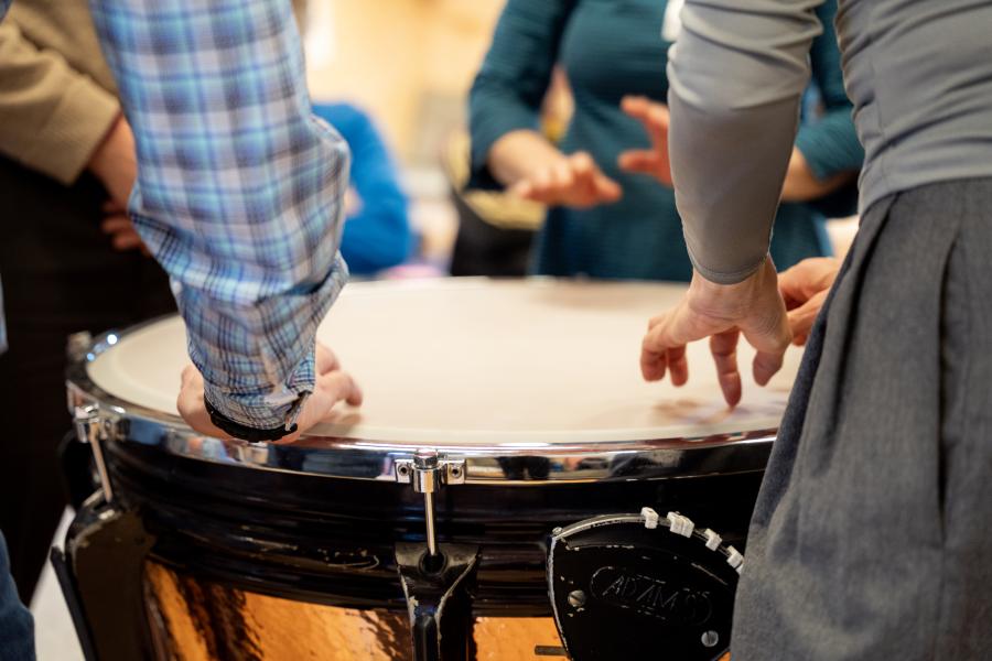 Blick auf viele Hände, die auf eine Pauke hauen
