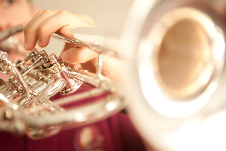 Blick auf eine silberne Trompete, gespielt von einem MHL-Studenten