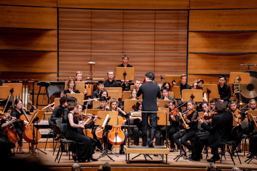 Blick auf den Dirigenten vor dem MHL-Sinfonieorchester auf der Bühne der Lübeck Musik- und Kongresshalle