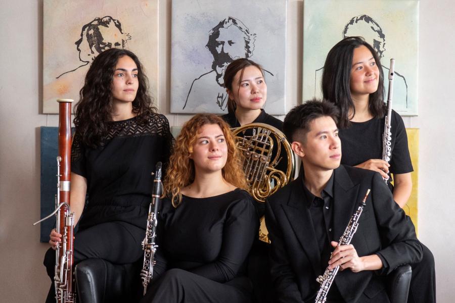 Quantum Quintet vor Brahms Gemälden. Schauen alle nach rechts mit Instrumenten in der Hand