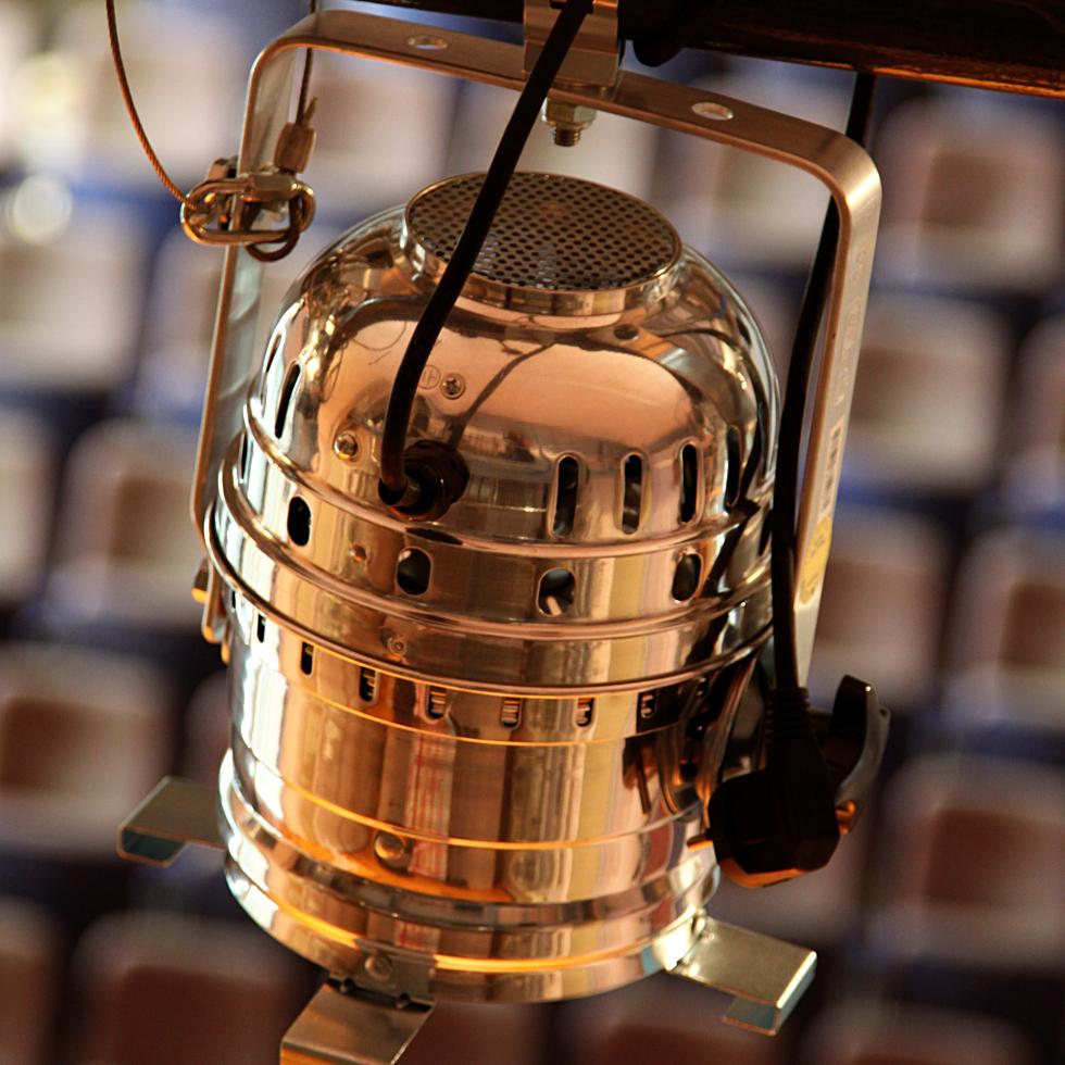 Ein Blick auf einen glänzenden Scheinwerfer, der über der Bühne des Großen Saals an der Decke hängt