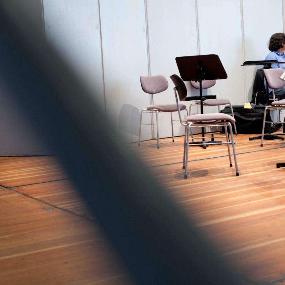 Blick auf die Bühne des Großen Saals mit vielen leeren Stühlen und Notenständern