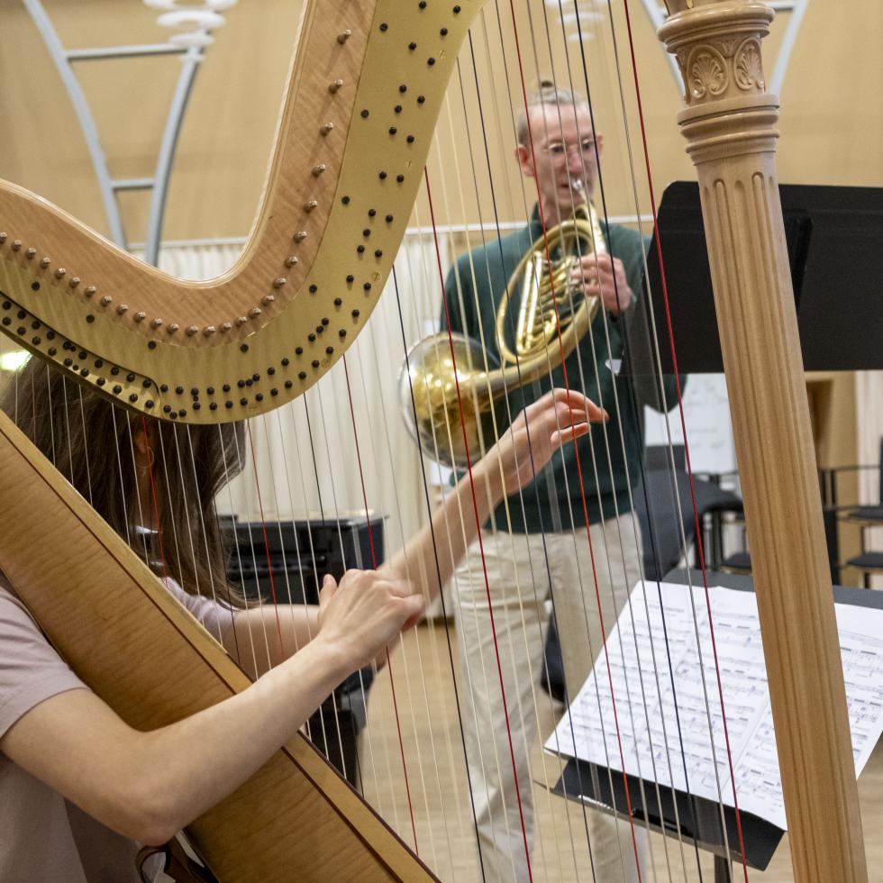 Blick auf eine Harfe spielende ISMA-Jungstudentin und einen ISMA-Hornisten 
