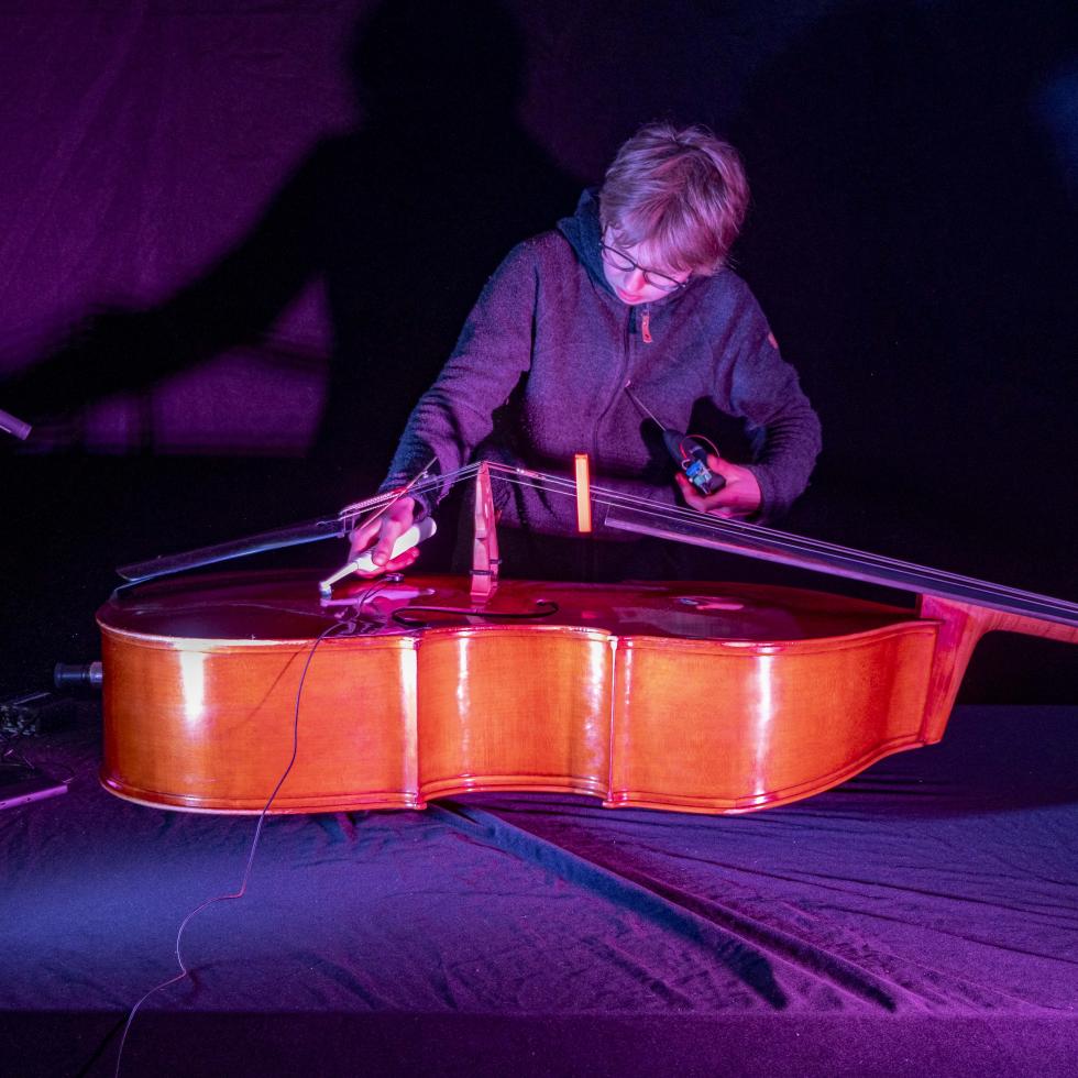 Blick auf einen Studenten, der einen Kontrabass technisch präpariert 