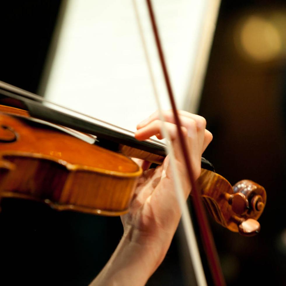 Blick auf eine Violine spielende Studentin