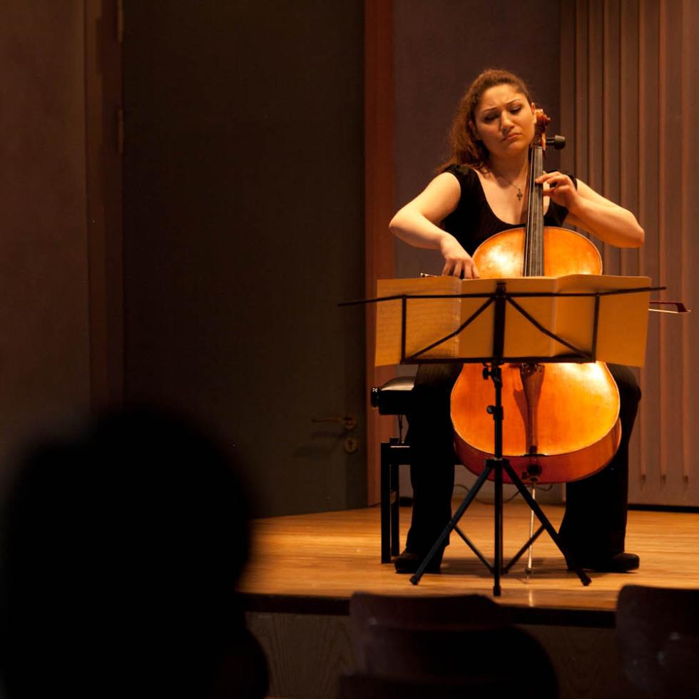 Blick auf eine Cellistin, die ein Konzert im MHL-Kammermusiksaal spielt.