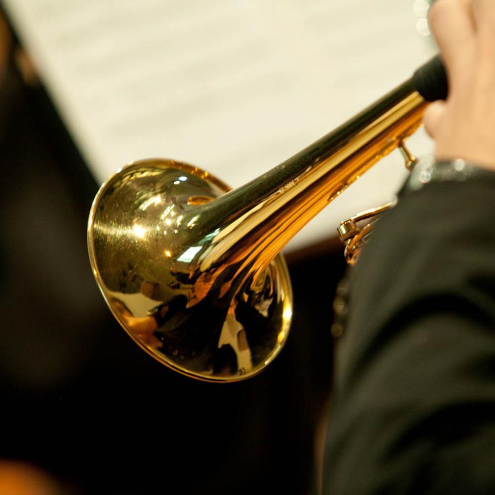 Blick von hinten auf einen Trompete spielenden Studenten