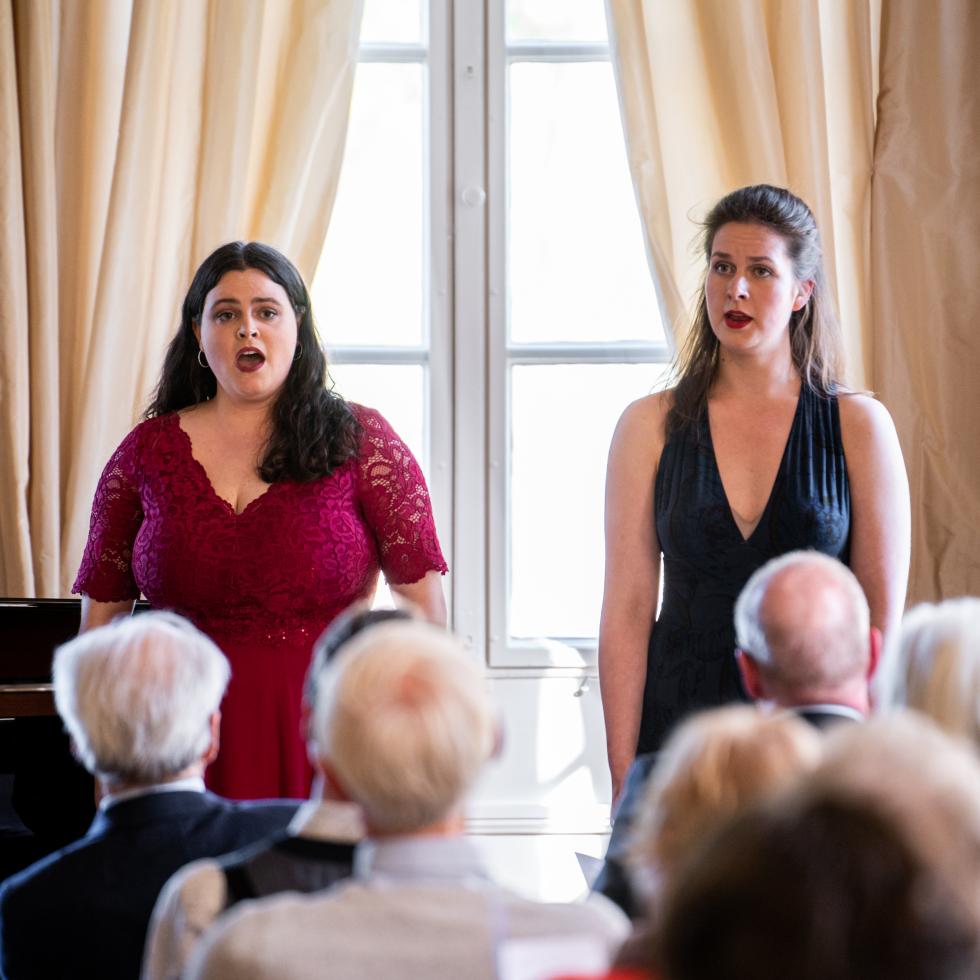 Blick auf zwei singende Studentinnen