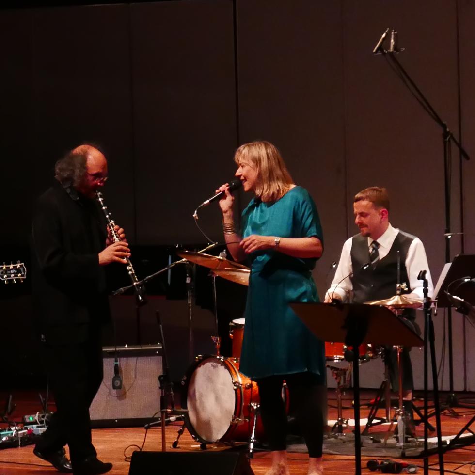 Blick auf drei Dozierende, die zusammen auf der Bühne des Großen Saals improvisieren