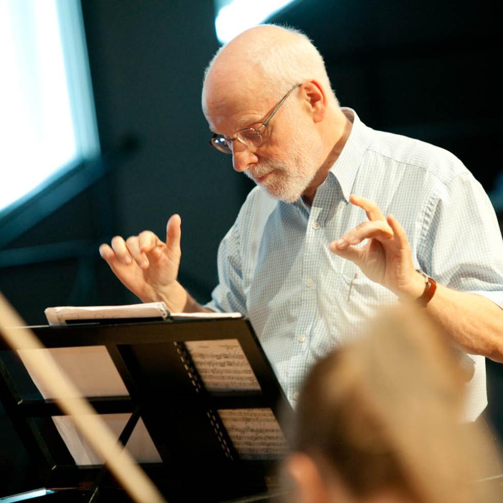 Ton Koopman dirigiert MHL-Ensemble Alte Musik, Schaut in die Noten richtung Notenständer, Etwas zur Seite gedreht