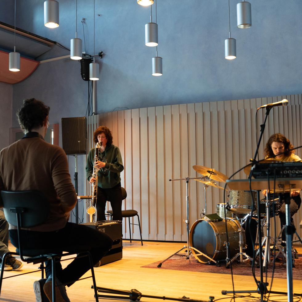 Blick auf die Bühne des Kammermusiksaals mit einer Gruppe von STudierenden, die für eine Improvisation proben