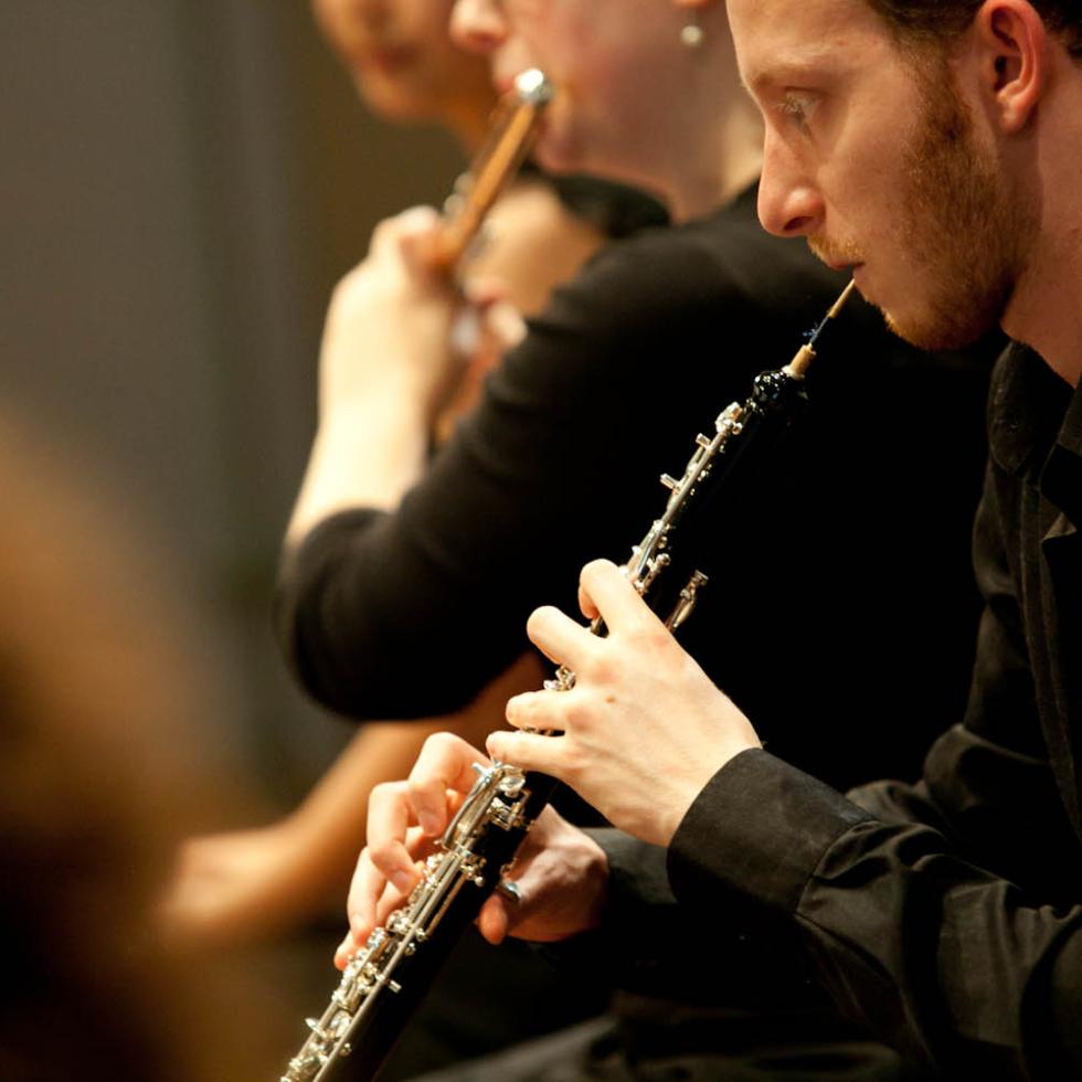 Nahaufnahme auf Studierende der MHL, die im MHL-SInfonieorcehster Holzblasinstrumente spielen 