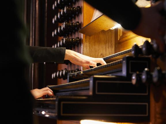 Blick auf eine Orgel spielende Studentin