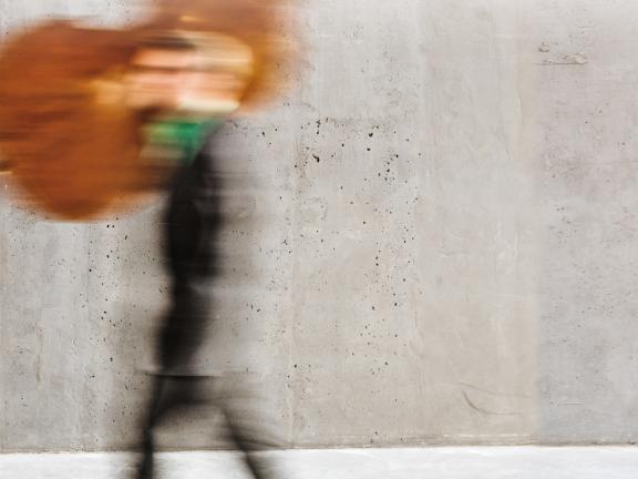 Blick auf das Titelbild der Reihe »Wir in«: ein Student, der seinen Kontrabass auf der Schulter trägt