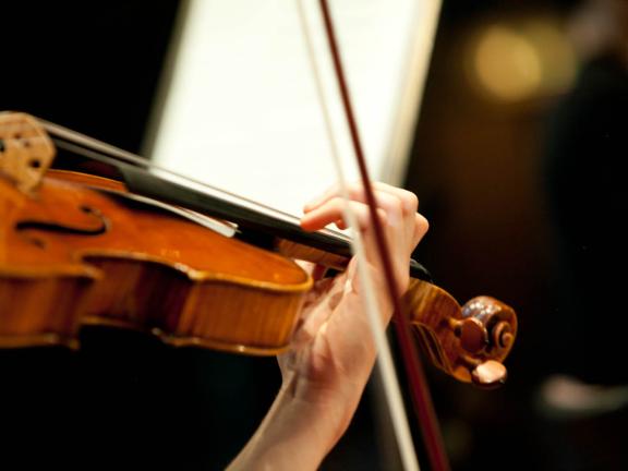 Blick auf eine Violine spielende Studentin