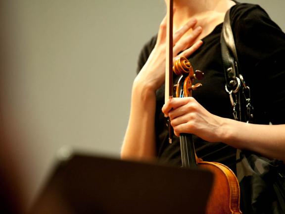 Blick auf eine Studentin, die ihre Violine in der Hand hält 